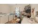 Small laundry room filled with a washer, dryer, shelves, and household items at 4122 Old Bradenton Rd, Sarasota, FL 34234