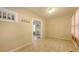 A bright room with neutral tones, tiled floors, coat hooks, and entry to another room with a fireplace at 4122 Old Bradenton Rd, Sarasota, FL 34234