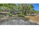 An ample yard features lush trees, glimpses of a two-story home, and offering an inviting outdoor setting at 4122 Old Bradenton Rd, Sarasota, FL 34234