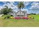 Elegant community sign with lush landscaping, vibrant flowers, and a calming water feature at 4206 Park Willow Ave, Palmetto, FL 34221