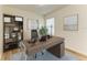 Home office with a wood desk, built in bookcase, window, neutral walls and decor at 4206 Park Willow Ave, Palmetto, FL 34221
