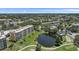 An aerial view displays a meticulously maintained condo community with a pond and golf course at 4570 Pinebrook Cir # 508, Bradenton, FL 34209