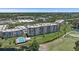 Aerial view of condo buildings, lush landscaping, golf course and a community pool, highlighting recreational amenities at 4570 Pinebrook Cir # 508, Bradenton, FL 34209