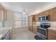 Bright kitchen area with stainless steel appliances, tile flooring, and natural-toned cabinets at 4570 Pinebrook Cir # 508, Bradenton, FL 34209
