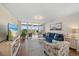 Comfortable living room with beach-themed decor, streaming television and sliding glass doors to a balcony at 4570 Pinebrook Cir # 508, Bradenton, FL 34209