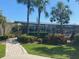 Community outdoor pool and lounge area with umbrellas, lush landscaping, and relaxing seating at 4570 Pinebrook Cir # 508, Bradenton, FL 34209