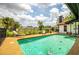 Backyard pool with a view of the house and surrounding trees on a sunny day at 4612 Masefield Pl, Sarasota, FL 34241