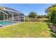 A lovely screened-in pool area overlooks a grassy yard and tranquil pond at 4758 Breezy Pines Blvd, Sarasota, FL 34232