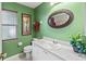 Bathroom features a decorative oval mirror, white vanity, and soft green colored walls at 4758 Breezy Pines Blvd, Sarasota, FL 34232