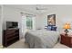 Comfortable bedroom with carpet flooring, ceiling fan, window and dresser with TV at 4758 Breezy Pines Blvd, Sarasota, FL 34232