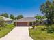 Aerial view of a well-maintained home with a long driveway, a garage and mature landscaping at 4758 Breezy Pines Blvd, Sarasota, FL 34232