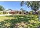 Charming single-story home with well-manicured lawn, mature trees, and a long driveway at 4758 Breezy Pines Blvd, Sarasota, FL 34232
