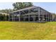 Wide backyard view of a screened-in patio and a well-manicured lawn at 4758 Breezy Pines Blvd, Sarasota, FL 34232