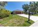 Charming home with a well-manicured lawn, mature trees, and a mailbox next to the driveway at 4758 Breezy Pines Blvd, Sarasota, FL 34232