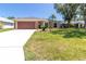 Inviting single-story home featuring a two-car garage, well-maintained lawn, and mature landscaping at 4758 Breezy Pines Blvd, Sarasota, FL 34232