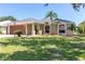 Charming single-story home featuring a well-manicured lawn and lush landscaping with decorative stone accents at 4758 Breezy Pines Blvd, Sarasota, FL 34232