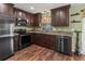 Modern kitchen featuring stainless steel appliances, granite countertops, and dark wood cabinetry at 4758 Breezy Pines Blvd, Sarasota, FL 34232