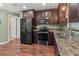 Modern kitchen featuring stainless steel appliances, granite countertops, and dark wood cabinetry at 4758 Breezy Pines Blvd, Sarasota, FL 34232