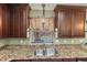 Kitchen sink with granite counters and brown cabinets overlooking the pool at 4758 Breezy Pines Blvd, Sarasota, FL 34232