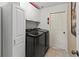 Laundry room with black washer and dryer and storage cabinets above with doors at 4758 Breezy Pines Blvd, Sarasota, FL 34232
