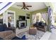 Covered outdoor patio with wicker furniture, TV, fireplace, and blue-and-white striped curtains at 4758 Breezy Pines Blvd, Sarasota, FL 34232