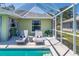Poolside lounge area with patio furniture and blue-and-white striped curtains in the background at 4758 Breezy Pines Blvd, Sarasota, FL 34232