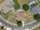 Overhead view of home with a screened-in pool, neat landscaping, and circular driveway at 4951 Brightstone Pl, Spring Hill, FL 34609