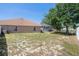 The backyard features minimal landscaping, the back of the home and a screen-enclosed pool at 4951 Brightstone Pl, Spring Hill, FL 34609