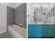 Bathroom features a combination tub/shower and turquoise double sink vanity with marble countertop at 4951 Brightstone Pl, Spring Hill, FL 34609