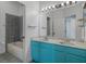 Bright bathroom featuring a double vanity, large mirror, and combined tub/shower at 4951 Brightstone Pl, Spring Hill, FL 34609
