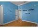 Bright bedroom features blue walls, wood floors, and floating shelves at 4951 Brightstone Pl, Spring Hill, FL 34609