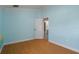 Bedroom with light blue walls and laminate wood flooring, open doorway into the bathroom at 4951 Brightstone Pl, Spring Hill, FL 34609