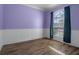Cozy bedroom with hardwood floors, wainscotting, and a large window at 4951 Brightstone Pl, Spring Hill, FL 34609