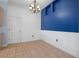 A dining room with a blue accent wall, white wainscoting and a modern chandelier at 4951 Brightstone Pl, Spring Hill, FL 34609