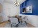 Dining room with a blue accent wall, white wainscoting and a round table with chairs at 4951 Brightstone Pl, Spring Hill, FL 34609