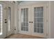 Bright foyer entrance featuring tiled floor and glass paneled double doors at 4951 Brightstone Pl, Spring Hill, FL 34609