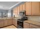 Kitchen boasting stainless steel appliances, light wood cabinets, granite counters, and tile flooring at 4951 Brightstone Pl, Spring Hill, FL 34609
