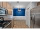 Eat-in kitchen with stainless steel fridge, light cabinets, tile floor and a blue accent wall at 4951 Brightstone Pl, Spring Hill, FL 34609