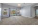 Bright living room with plush carpeting and sliding doors leading to the pool area at 4951 Brightstone Pl, Spring Hill, FL 34609