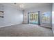 Sunlit living room with plush carpeting and large windows overlooking the pool area at 4951 Brightstone Pl, Spring Hill, FL 34609