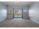 Bright empty living room with plush carpeting and sliding glass doors opening to the pool at 4951 Brightstone Pl, Spring Hill, FL 34609