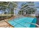 Inviting screened-in pool with waterfall and lush landscaping at 4951 Brightstone Pl, Spring Hill, FL 34609