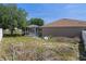 View of the back of the home with a screen-enclosed pool and minimal landscaping at 4951 Brightstone Pl, Spring Hill, FL 34609