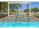A beautiful hot tub spills into a pool, set in a screen-enclosed outdoor space at 4951 Brightstone Pl, Spring Hill, FL 34609
