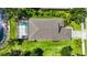 Aerial view of a home's roof, pool, and patio surrounded by lush greenery at 5020 Torrey Pines Run, Bradenton, FL 34211