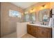 This bathroom features double sinks and a glass enclosed shower with a window at 5020 Torrey Pines Run, Bradenton, FL 34211