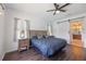 This main bedroom features a ceiling fan, two windows, and a barn door leading to the main bathroom at 5020 Torrey Pines Run, Bradenton, FL 34211