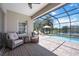 Inviting screened-in patio featuring comfortable seating, a dining area, and a view of the pool and lake at 5020 Torrey Pines Run, Bradenton, FL 34211