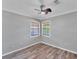 Bedroom features laminate flooring, light gray walls, and a ceiling fan at 513 25Th W Ave, Bradenton, FL 34205