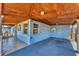 View of the covered carport with wood paneled ceiling, textured blue exterior, and tile flooring at 513 25Th W Ave, Bradenton, FL 34205